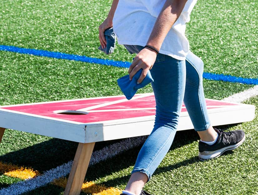 Person Throwing A Cornhole Bag